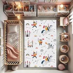 May include: A white play rug with a repeating pattern of knights, castles, rainbows, and stars. The rug is perfect for a child's playroom or bedroom.