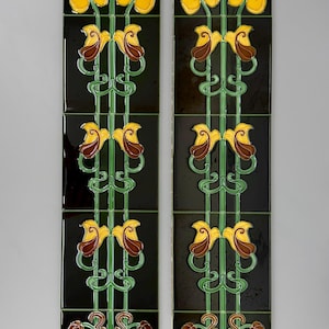 May include: Two vertical columns of four square ceramic tiles each, featuring a glossy black background with a repeating floral pattern. The design displays yellow blossoms, green stems, and brown leaf accents in a symmetrical, stylized arrangement.