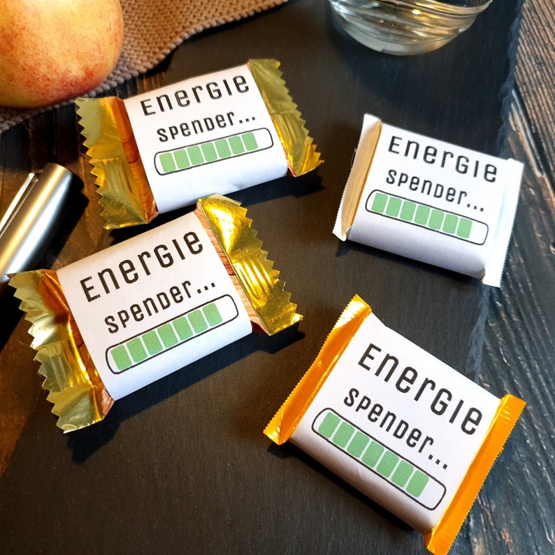May include: Four small wrapped chocolate bars with a gold foil wrapper and a white label that says "Energie spender..." with a green progress bar.