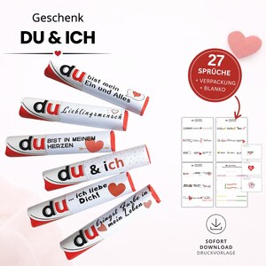 Puede incluir: Una colección de tubos blancos con detalles rojos, cada uno con la palabra "du" y una frase romántica en alemán, como "bist mein Ein und Alles". La imagen también incluye un conjunto de tarjetas imprimibles con citas de amor y un corazón rosa.