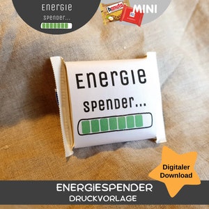 Puede incluir: Una plantilla imprimible para una pequeña bolsa de regalo con el texto "Energie Spender..." y una barra de progreso verde. La bolsa está sobre un fondo de tela marrón. El texto "Digitaler Download" está en una estrella amarilla.