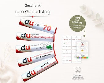 May include: A collection of white and red candy bars with German text, stacked diagonally. The bars have phrases like "du bist 70" and "Geburtstagskind." A set of small cards with birthday messages and a download icon are also visible.