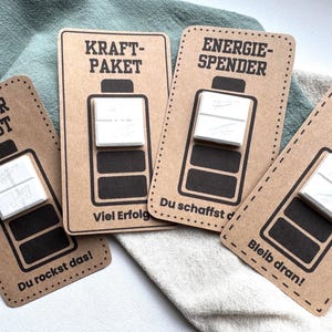 Digitale PDF-Druckvorlage mit 4 Motivkarten im Batterie-Design, Sprüche wie „Energiespender“ und „Power Boost“, zum Befestigen von Dextro-Energy-Täfelchen, Geschenkidee zur Motivation.
