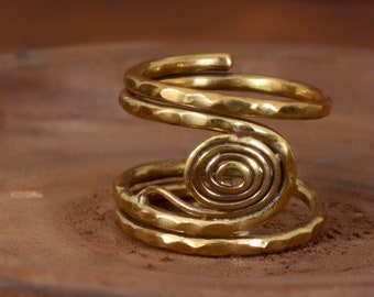 May include: A gold-toned ring with a hammered finish and a spiral design. The ring is made of metal and has a simple, elegant style.