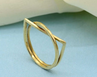 May include: A gold-toned ring with a geometric design. The ring is made of two bands, one of which is a simple circle and the other is a triangle with rounded corners. The bands are intertwined.