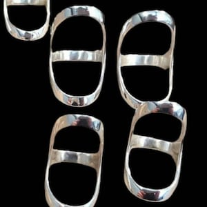 May include: Five silver rings with a double-ring design. The rings are oval shaped and have a smooth, polished finish.