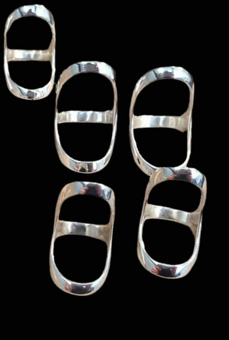 May include: Five silver rings with a double-ring design. The rings are oval shaped and have a smooth, polished finish.