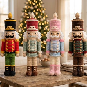 Op de afbeelding: Vier gehaakte notenkrakerpoppen staan op een rij. Elke pop draagt een hoge hoed, een uniform met knopen en laarzen. De poppen hebben verschillende kleurenschema's met garentexturen in rood, groen, zwart, lichtblauw, roze en bruin.