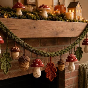 May include: A crochet garland featuring alternating red and white spotted mushrooms, brown acorns, and green and orange oak leaves hanging from a thick, braided green yarn cord. The handmade textile decorations are suspended in a repeating pattern.