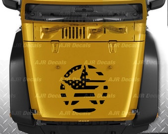 Könnte beinhalten: Ein gelber Jeep Wrangler mit einem schwarz-weißen Aufkleber der amerikanischen Flagge auf der Motorhaube. Der Aufkleber hat die Form eines Sterns.