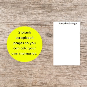 May include: Two blank scrapbook pages are displayed on a wooden surface. A yellow circle contains the text: "2 blank scrapbook pages so you can add your own memories." The right page has the text "Scrapbook Page".