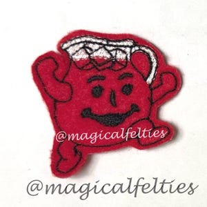 May include: A red felt patch shaped like a pitcher character with a smiling face, black embroidered eyes and mouth, and a white top section. The text @magicalfelties is embroidered in white across the center and printed below the patch.