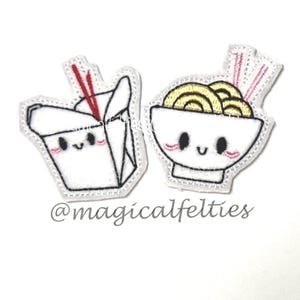 May include: Two embroidered felt patches featuring a white takeout box with red chopsticks and a white bowl of yellow noodles with pink chopsticks. Both items have black outlines, black eyes, and pink cheeks. The text @magicalfelties is visible.