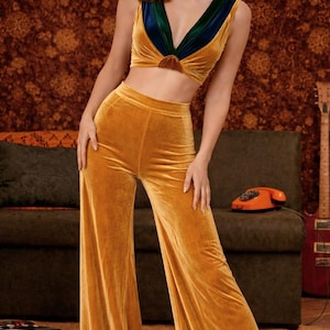 Completo ispirato agli anni '70 composto da pantaloni a gamba larga in velluto e crop top, outfit boho retrò dorato.