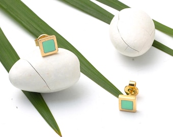 May include: A pair of gold square earrings with a light green enamel center.