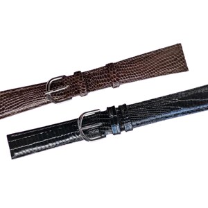 Puede incluir: Dos correas de reloj, una marrón y otra negra, con textura de cuero con estampado de cocodrilo. Ambas correas tienen hebillas plateadas.