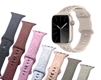 May include: A set of eight Apple Watch bands in various colors and patterns. The bands are made of silicone and feature a floral design. The bands are shown on a white background.
