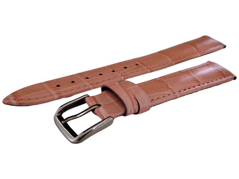 K&ouml;nnte beinhalten: Hellrosa Uhrenarmband mit Krokodilmuster. Das Armband hat eine silberfarbene Schnalle und mehrere L&ouml;cher zur Anpassung. Das Uhrenarmband besteht aus einem strukturierten Material.