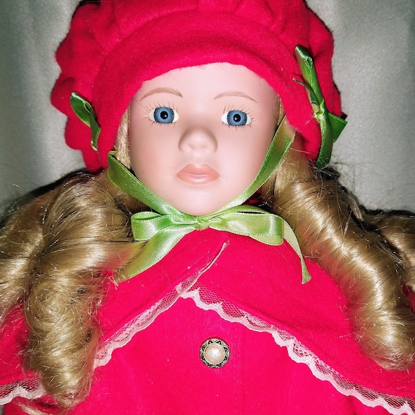 Vintage Porcelain Doll in Red Felt Coat Lined in Lace and Hat with Green Bows.