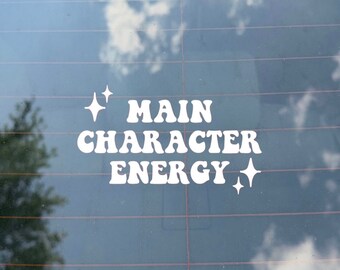 May include: White vinyl sticker with the text "Main Character Energy" in a retro font with two small stars on either side of the text.
