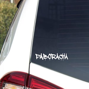 May include: White vinyl decal with the word "PABORACHA" in a graffiti-style font, applied to the rear window of a white vehicle. The decal has a dripping effect.