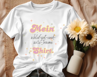 May include: White t-shirt with a pink and yellow graphic that says "Mein schlaf-gut-und-süße-Träume -Shirt."