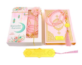 May include: A pink and gold Ramadan gift set with a Quran, prayer beads, a bookmark, and a prayer rug. The set is personalized with the name "Amara".