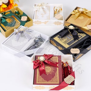 May include: Five gift boxes with gold trim and decorative bows. Each box contains a Quran and prayer beads. The boxes are in different colors, including green, white, gold, black, and red.