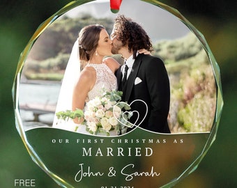 May include: A clear glass Christmas ornament with a photo of a couple kissing. The ornament has the text "Our First Christmas as Married John & Sarah 01.21.2024" printed on it.