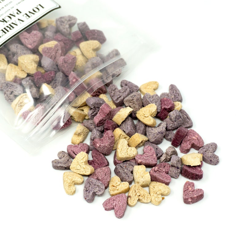 Tri-flavoured bite-sized treats for small animal flowing out of its clear packaging