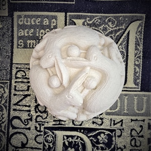 May include: A white ceramic sculpture of four rabbits intertwined in a circle. The rabbits are carved in a realistic style and have detailed features. The sculpture is a beautiful example of craftsmanship.