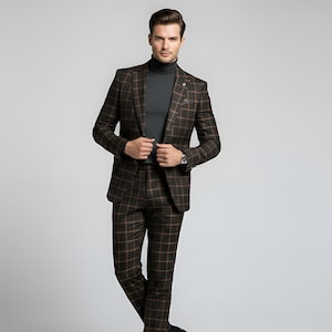 May include: A brown and black plaid suit with a matching jacket and pants. The suit features a classic design with a subtle pattern. The person is wearing a dark gray turtleneck. A watch is visible on the wrist.