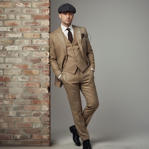 May include: A three-piece tan pinstripe suit with a matching vest, white dress shirt, and brown tie. The suit includes a pocket square and a pocket watch. The person is wearing a gray flat cap and black dress shoes.