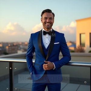 May include: A formal blue suit with a black lapel, vest, and bow tie. The suit includes a white dress shirt and a pocket square. The person is smiling and leaning against a railing, with a city skyline in the background.