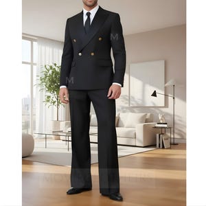 Puede incluir: Un traje negro de doble botonadura con botones dorados, una camisa blanca y una corbata negra. El traje tiene un corte a medida con pantalones de pernera ancha. La imagen muestra a una persona que lleva el traje en un entorno interior moderno y bien iluminado.