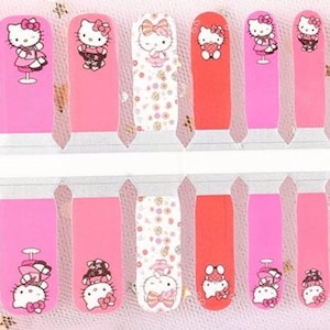 May include: A sheet of nail stickers featuring Hello Kitty in various poses. The stickers are on a white background with pink and red accents. The stickers are designed for use on fingernails.