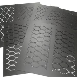 Könnte beinhalten: Eine Sammlung schwarzer Metallschablonen mit verschiedenen geometrischen Ausschnittmustern. Zu den Designs gehören Diamant-, Sechseck- und Zickzackformen. Die Schablonen sind fächerartig angeordnet und zeigen die verschiedenen Designoptionen.