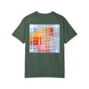 May include: Dark green t-shirt with a colorful, abstract graphic on the back. The graphic features a mix of geometric shapes, faces, and patterns in shades of orange, blue, and red. The text "GABRIEL GOMEZ" is printed at the bottom of the graphic.