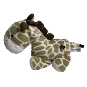 May include: A plush brown and white giraffe toy with a brown nose and black eyes. The giraffe is lying on its belly with its legs outstretched. The toy has a small black button on its back and a tag that reads 'Carter's'.