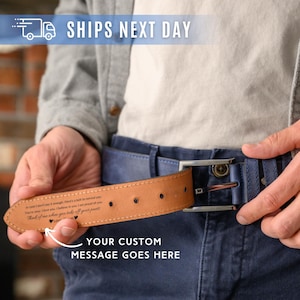 May include: A brown leather belt with a blue belt strap and a silver buckle. The belt has a custom message area. The image also includes the text "YOUR CUSTOM MESSAGE GOES HERE".
