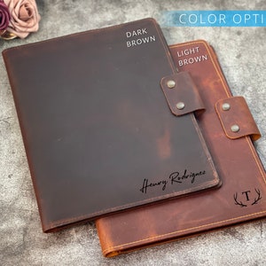May include: Two leather folios in dark brown and light brown. The dark brown folio has the name "Henry Rodriguez" in script. The light brown folio has the letter "T" inside a wreath. The words "Color Options" are at the top.