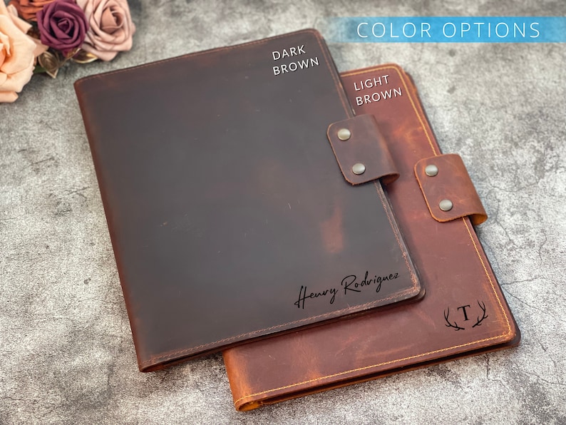 May include: Two leather folios in dark brown and light brown. The dark brown folio has the name "Henry Rodriguez" in script. The light brown folio has the letter "T" inside a wreath. The words "Color Options" are at the top.