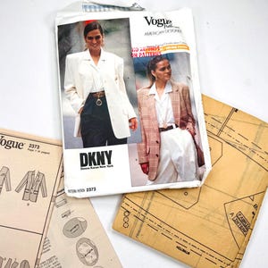 Puede incluir: Un sobre de patrón de costura Vogue American Designer para DKNY Donna Karan New York, número 2373, que presenta dos estilos de blazer. Incluye hojas de instrucciones impresas y piezas de patrón de papel marrón con dibujos técnicos y texto.