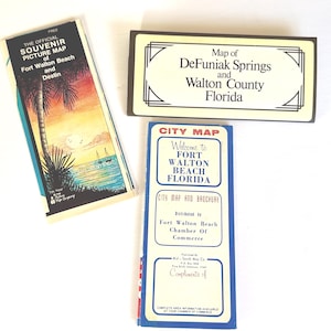 Puede incluir: Tres mapas antiguos de Florida: un mapa de recuerdo de Fort Walton Beach y Destin, un mapa de DeFuniak Springs y el condado de Walton y un mapa de la ciudad de Fort Walton Beach. Los mapas están sobre un fondo blanco.