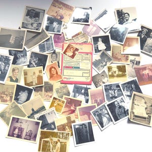 May include: A collection of vintage photographs, in various sizes and orientations, scattered on a white surface. The photos are primarily black and white, with some color images. Subjects include people, events, and landscapes, with a pink and white document.