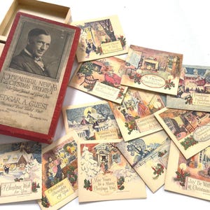 Könnte beinhalten: Ein Vintage-Set aus Weihnachtskarten und einer roten Box. Die Box zeigt ein Porträt und den Text "12 Beautiful New Christmas Thoughts". Die Karten zeigen Winterszenen und festliche Grüße.