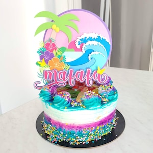May include: A colorful cake decorated with a tropical theme. The cake is topped with a pink and blue wave, a green palm tree, and a pink sign that says "mafafa".