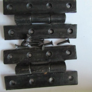 May include: Set of four black metal hinges with screws. The hinges are designed for use on doors or cabinets.