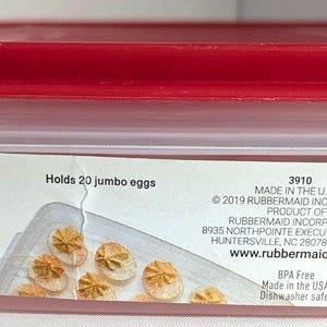 May include: A clear plastic Rubbermaid Egg Keeper with a red lid. The container holds 20 jumbo eggs and measures 2.24 x 8.98 x 12.99 inches. The label includes the Rubbermaid logo and product information.