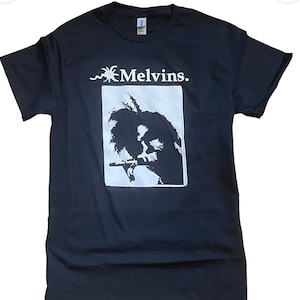 May include: Black t-shirt with a white graphic of a person playing a musical instrument. The graphic is in a white rectangle with the text "Melvins." above it.